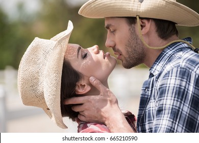 Young Sensual Cowboy Style Couple Kissing With Eyes Closed Outdoors