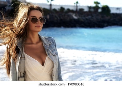 young sensual woman with streaming hair walking at beach