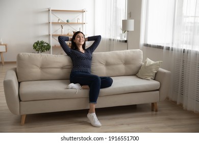 Young serene asian woman rest on soft stylish couch after finishing household chores enjoy tranquility feeling satisfied. Peaceful vietnamese lady chill at modern studio apartment breath fresh air nap - Powered by Shutterstock