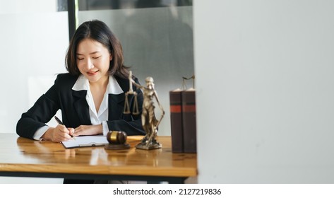 Young Serious Asian Female Ceo Lawyer Businesswoman Sitting At Desk Working Typing On Laptop Computer In Contemporary Corporation Office. Business Technologies Concept.