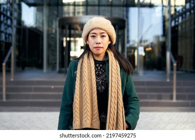 Young Serious Asian Woman Looking Camera. Chinese Lady Outdoors Near Corporative Buildings At The City