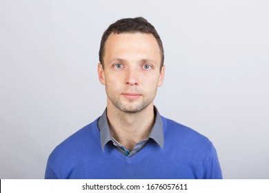 Young Serious European Man In Smart Casual Clothing, Studio Face Portrait Over Gray Wall Background