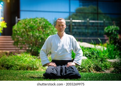  Young serious man aikido master in traditional costume 