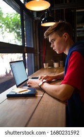 Young Serious Man With Pensive Look Experienced Freelance Worker Create Account On Laptop Computer While Sitting In Coffee Shop During Free Time. Hipster Guy Online Booking Via Notebook 