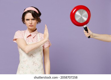 Young Serious Sad Housewife Housekeeper Chef Cook Baker Woman In Pink Apron Hand Hold Red Pan Show Stop Palm Gesture Isolated On Pastel Violet Background Studio Portrait Cooking Food Process Concept.