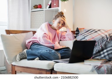 Young Serious Student Talking On Online Chat Meeting Using Laptop At Home. College Female Student Learning Remotely. Sad Teen Girl Distant Learning