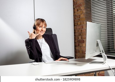 Young Service Employee Sits In Front Of The Screen With A Headset And Gives The Request To Call