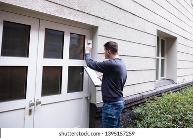 Young Service Man Examining Closed Door At The Entrance - Shutterstock ID 1395157259