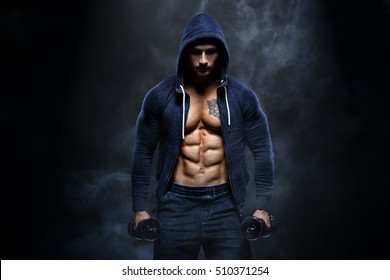 Young sexy bodybuilder with perfect body doing exercise with barbell on black background . smoke effect on the background
Strong man with muscle cubes on press. Sport concept image