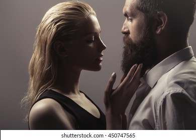 Young Sexy Couple Of Pretty Woman With Blonde Hair And Handsome Bearded Man With Long Beard Embracing On Grey Background