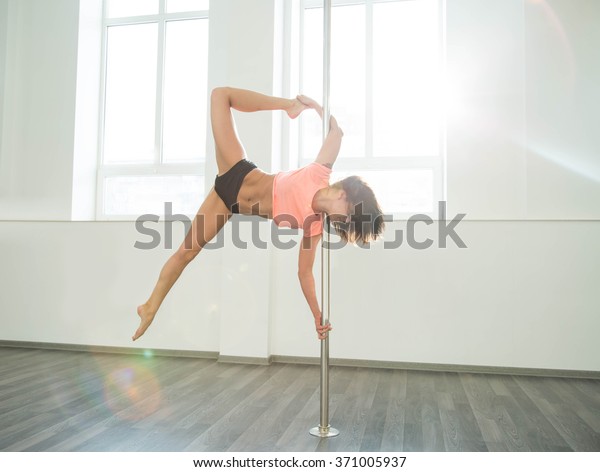 Young sexy
pole dance woman. Bright white
colors.