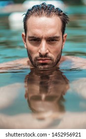 Young Sexy Shirtless Man Emerging From Water Surface Looking At You Seductively