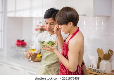 Young Sexy Topless LBGT Man With Red Apron Make Salad To His Boyfriend At Kitchen. Lovely Gay Couple. Healthy Breakfast Eating Lifestyle For Same Sex Family In Morning.