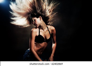 Young Sexy Woman In Blue Jeans And  Brassiere Dancing, Studio Shot