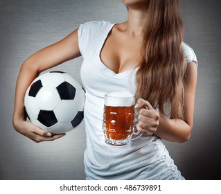 young sexy woman holding soccer ball and beer mug. Open breast. Closeup.