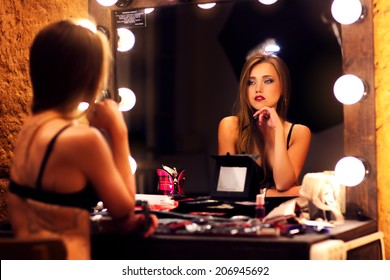 Young sexy woman looking at mirror.
