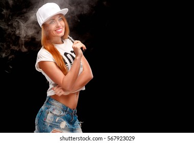 Young sexy woman is vaping ( smoking ) e-cigarette.  cloud of vapor. Black background.
