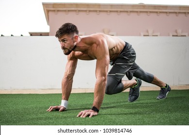 Young shirtless muscular man warming up before a workout outdoors. - Powered by Shutterstock