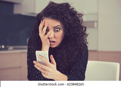 Young shocked anxious woman looking at phone seeing bad news photos text message with scared emotion on face 