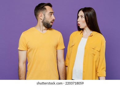 Young Shocked Surprised Couple Two Friends Family Amazed Man Woman 20s Together Wearing Yellow Casual Clothes Look To Each Other With Opened Mouth Isolated On Plain Violet Background Studio Portrait