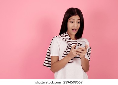 Young shocked teenage girl with bag on pink background in studio. - Shutterstock ID 2394599559