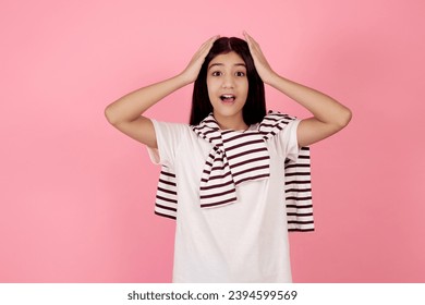 Young shocked teenage girl on pink background in studio. - Shutterstock ID 2394599569