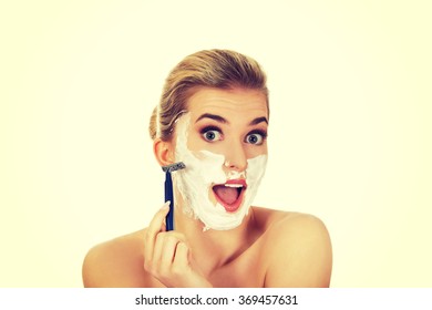 Young Shocked Woman Shaving Her Face With A Razor