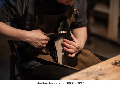 a young shoemaker in a Shoe shop makes shoes from leather with his own hands. - Powered by Shutterstock