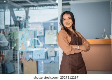 Young shopkeeper girl with hands crossed smiling happy leaning window at the gift shop - Powered by Shutterstock