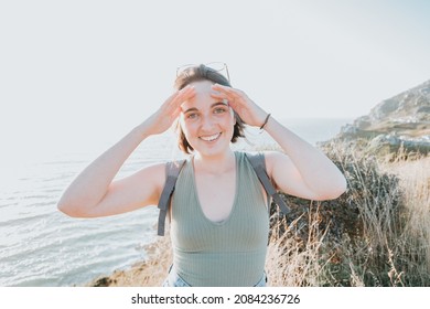 Young short hair woman on glasses, looking to camera while smiling and saluting, freedom and liberty concepts, traveling and hiking concept, road route style, hipster lifestyle,copy space