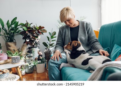 Young short haired blonde woman spending day with her dog pet at home. Best friend forever and pet therapy. Lifestyle with pets