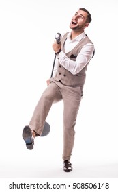 Young Showman In Suit Dance And Singing With Emotions Gesture Over The Microphone With Energy. Isolated On White Background. Singer Concept.