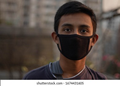 Young sick boy wears a black safety mask.Mask prevents corona virus and air pollution dust.New type coronavirus 2019-nCoV pneumonia in Wuhan has been spreading into many Countries.Man wearing mask