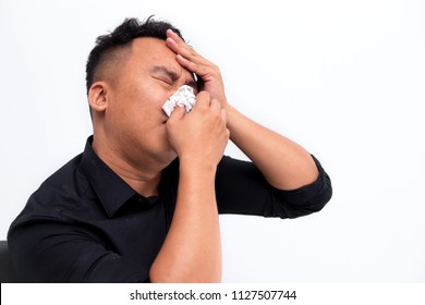 Young Sick And Ill Asian Man Holding Tissue Cleaning Snotty Nose Having Temperature Feeling Bad Infected By Winter Grippe Virus In Flu And Influenza Health Care Concept.