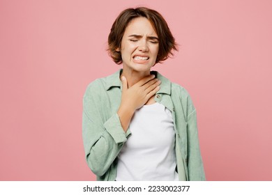 Young sick ill sad woman 20s she wear green shirt white t-shirt put hand on neck suffer from sore throat flu isolated on plain pastel light pink background studio portrait. People lifestyle concept - Shutterstock ID 2233002377