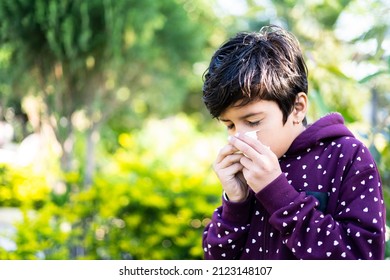 Young Sick Kid Sneezing At Park During Winter - Concept Of Seasonal Winter Illness, Flu And Infection