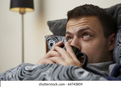 Young Sick Man In The Bed And Drinking Tea.