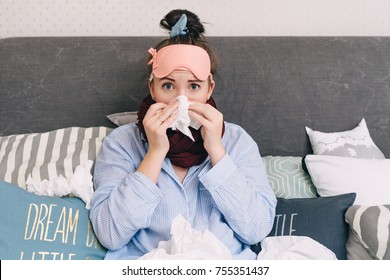 Young Sick Woman In Bed With Flu And Cold Blowing Her Nose