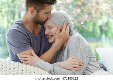 Young sick woman being kissed on the head 