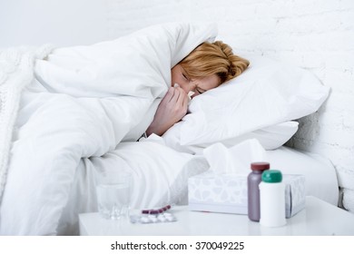 Young Sick Woman With Sneezing Nose Blowing In Tissue Lying On Bed Suffering Winter Cold And Flu Virus Symptoms Having Medicines Tablets And Pills In Illness And Domestic Health Care Concept