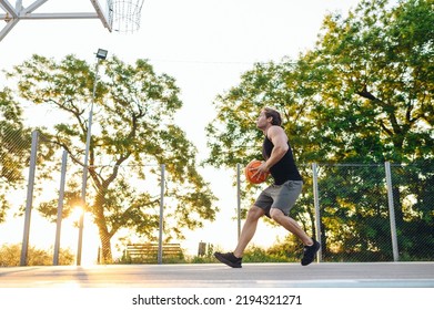 Young Side View Sporty Strong Caucasian Sportsman Man Wearing Sports Clothes Training Shooting Free Throw Run Playing With Ball At Basketball Game Playground Court. Outdoor Courtyard Sport Concept.