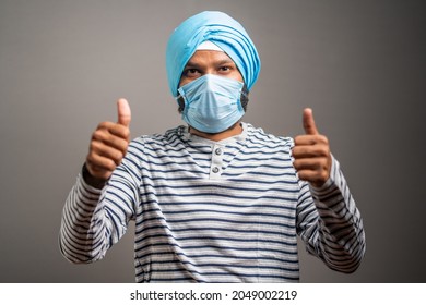 Young Sikh Man With Medical Face Mask Recommending To Wear Face Mask By Showing Thumbs Up Gesture During Coronavirus Covid-19 Pandemic