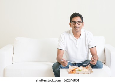 Young Single Indian Man Eating Food Alone, Copy Space At Side. Having Nasi Lemak As Lunch. Lifestyle Of Asian Guy At Home.