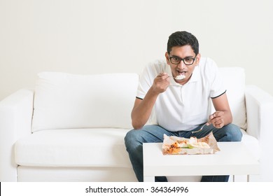 Young Single Indian Man Eating Food Alone. Having Nasi Lemak As Lunch. Lifestyle Of Asian Guy At Home.