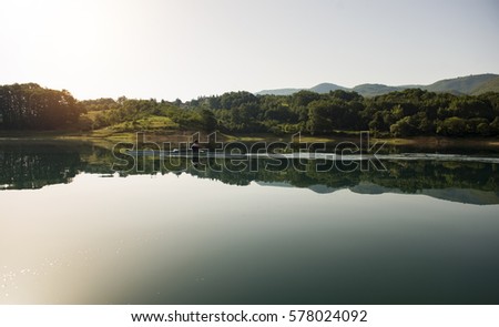 A Young single scull rowing competitor paddles on the tranquil lake