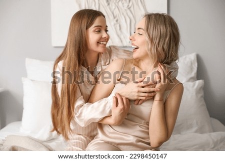Young sisters hugging in bedroom