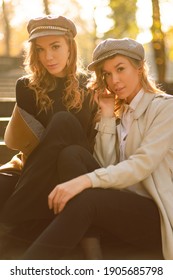 Young Sisters Sitting On Stairs In Fashion Clothes. Fall Picture