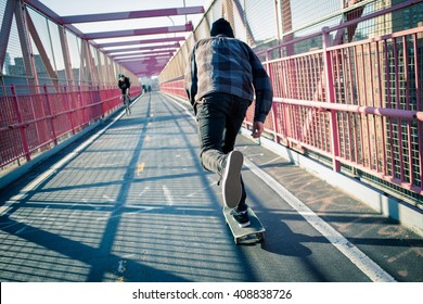 Young skateboarder speed through the pedestrian walkway on Williamsburg Bridge, NYC. Photographed in Feb 2016. - Powered by Shutterstock