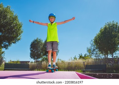 Young Skater Boy With Green Hair Ride Standing On Skateboard On The Pink Ramp In Skatepark In Blue Helmet