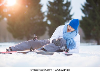 Young Skier Screaming And Keeping His Hands On Hurt Knee While Lying In Snowdrift